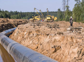 An image of an oil pipeline, heavy machinery, and construction workers to depict ground disturbance training.