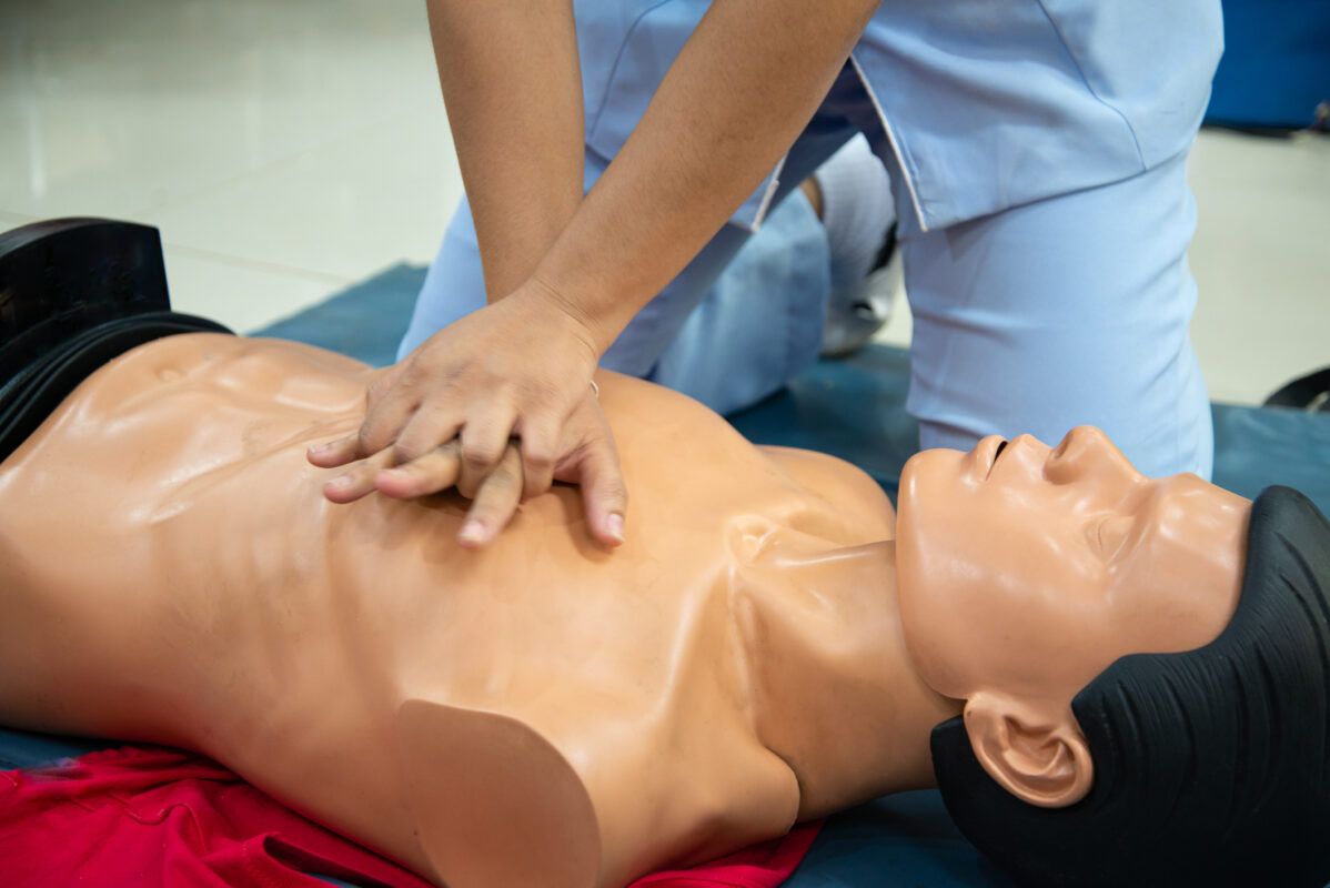 Instructor performing CPR on a training dummy.
