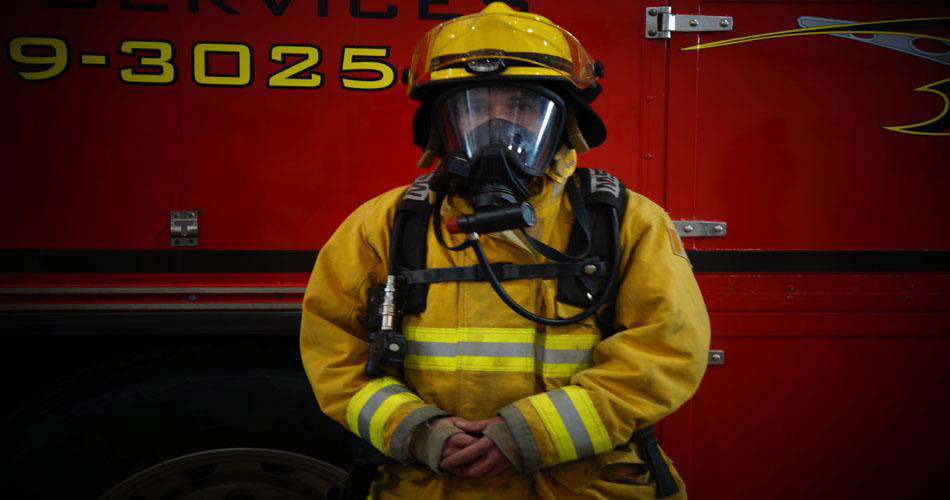 Man in a fire fighting outfit.