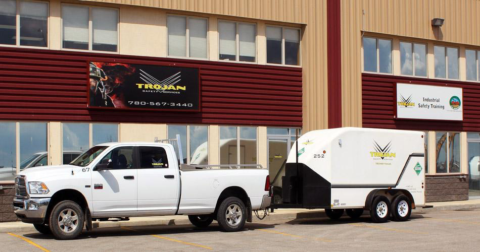 Truck and trailer in front of Trojan building.