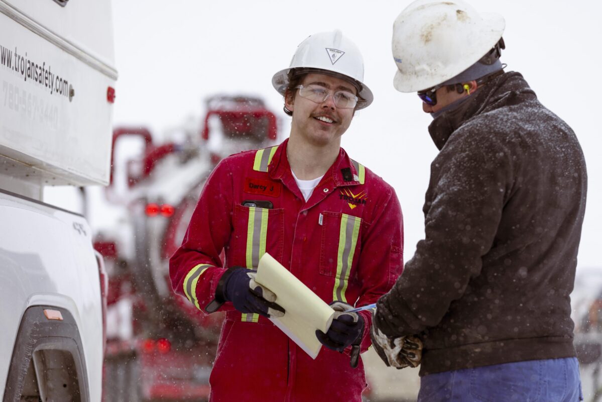 Trojan Safety employees having a conversation outside while snowing.