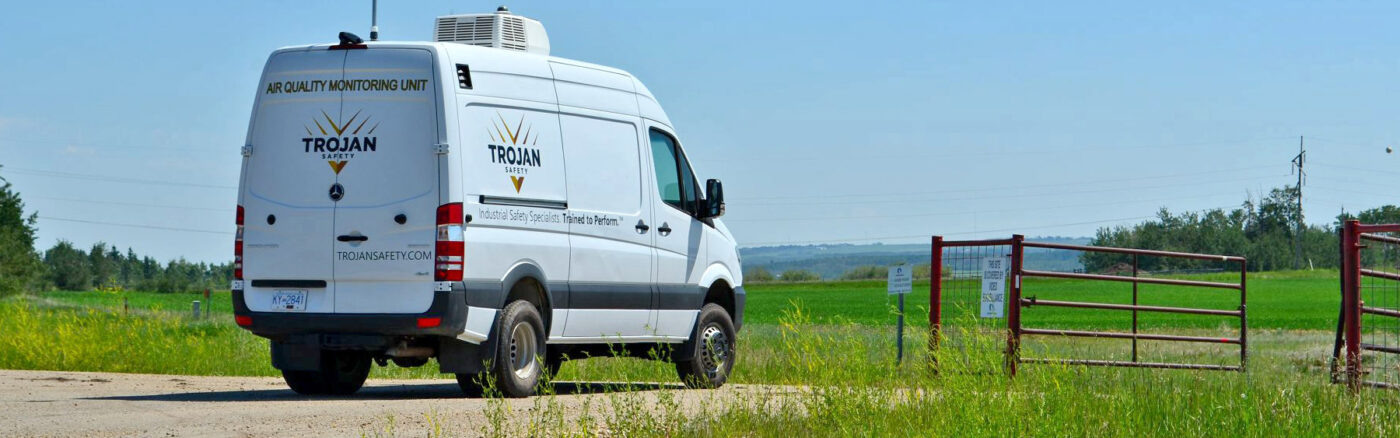 Trojan Safety van driving down a rural gravel road in Sylvan Lake.