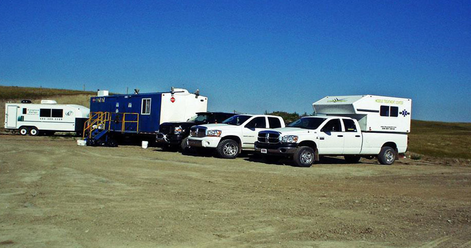 Various Trojan Safety vehicles parked in rural Sylvan Lake.
