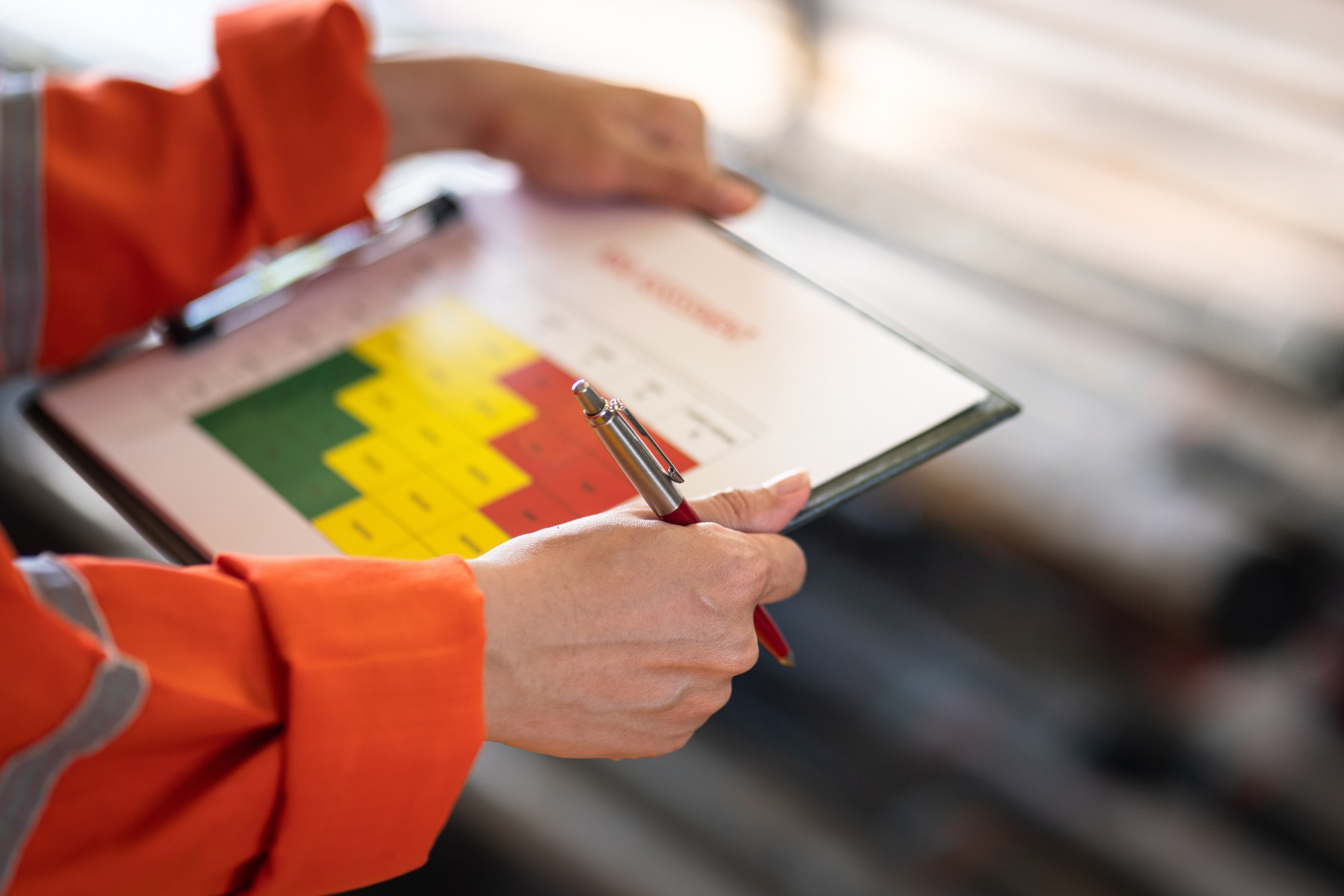 An industrial worker holding a risk assessment matrix