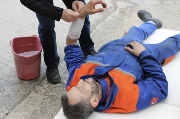 Oilfield medic performing first aid on an injured worker in a remote work environment.